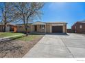 A single-story home featuring a driveway leading to a garage, complemented by a well-maintained front lawn at 11674 Claude Ct, Northglenn, CO 80233