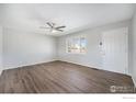 Bright living room features wood-look flooring, a ceiling fan and a window for natural light at 11674 Claude Ct, Northglenn, CO 80233