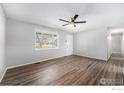 Bright living room features wood-look flooring, ceiling fan and a window for natural light at 11674 Claude Ct, Northglenn, CO 80233
