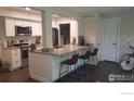 Modern kitchen featuring white cabinets, stainless appliances, and an eat-in bar with seating at 1180 Monroe Dr # C, Boulder, CO 80303