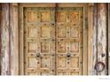 Close-up of a unique, weathered wood double door with metal accents at 1440 Reed Ranch Rd, Boulder, CO 80302