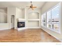 Spacious living room featuring a fireplace, hardwood floors, and large shuttered windows at 1810 Signature Ct, Longmont, CO 80504