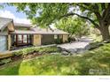 Charming home with a well-manicured lawn, mature trees, and a long driveway at 230 Cactus Ct, Boulder, CO 80304