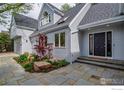 Charming home exterior featuring light gray siding, a black front door, and professionally landscaped front yard at 2672 Winding Trail Dr, Boulder, CO 80304
