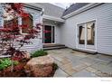 Home exterior showcasing a stone patio, well-maintained landscaping, and inviting entrance at 2672 Winding Trail Dr, Boulder, CO 80304