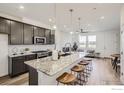 Modern kitchen features a large island with granite countertops, seating for four, and stainless steel appliances at 2729 Bear Springs Cir, Longmont, CO 80503