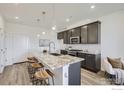 Bright kitchen with sleek grey cabinets, granite countertops, and a spacious island, flowing into the living space at 2729 Bear Springs Cir, Longmont, CO 80503