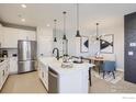 Well-lit kitchen features stainless steel appliances, a center island, and an adjacent dining area at 2759 Bear Springs Cir, Longmont, CO 80503