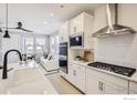 Bright, open kitchen with white cabinets, stainless steel appliances, and a view into the living area at 2759 Bear Springs Cir, Longmont, CO 80503