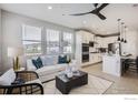 Open-concept living room with modern furnishings, large windows, and a seamless flow into the kitchen at 2759 Bear Springs Cir, Longmont, CO 80503