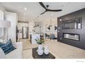 Open-concept living area with kitchen island, stainless appliances, a dining nook, and a modern fireplace wall at 2759 Bear Springs Cir, Longmont, CO 80503