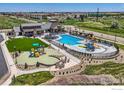Aerial view of a community pool area with a splash park, seating, and manicured landscaping at 2759 Bear Springs Cir, Longmont, CO 80503