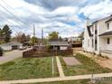 Charming home features a fenced yard, grassy lawn, and a stone patio area at 3001 Chase St, Wheat Ridge, CO 80214