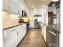 Modern kitchen with stainless steel appliances and a tile backsplash at 3401 Arapahoe Ave # 402, Boulder, CO 80303