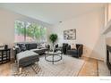 Bright living room with hardwood floors, a large window, comfortable seating, and a fireplace at 3617 Blanca Peak Dr, Superior, CO 80027