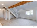 Cozy living room featuring a staircase, large window, and neutral carpet at 4877 Darwin Ct, Boulder, CO 80301
