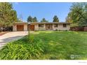 Charming single-story home boasts a well-maintained lawn, mature trees, and a spacious two-car garage at 5604 Bowron Pl, Longmont, CO 80503