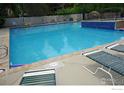 Community pool with clear water, lounge chairs, and a fence for safety and privacy at 6036 Gunbarrel Ave # B, Boulder, CO 80301