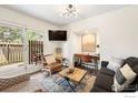 Cozy living room with natural light, a desk, and a sliding glass door to the patio at 8050 Niwot Rd # 31, Niwot, CO 80503