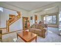 Cozy living area showcasing a large window, adjacent to the dining area, and stairs to the upper level at 8574 W 94Th Ave, Westminster, CO 80021
