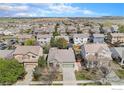 An aerial view showing a neighborhood featuring a one-story home with green siding and a two-car garage at 9674 Joplin St, Commerce City, CO 80022