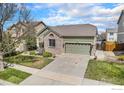 Charming one-story home with green siding, brick accents, landscaped front yard and a two car garage at 9674 Joplin St, Commerce City, CO 80022