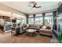 Open-concept living area with fireplace, large windows, and views to the kitchen at 10834 Graphite St, Broomfield, CO 80021