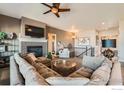 Spacious living room featuring a cozy fireplace, large couch and open floorplan at 10834 Graphite St, Broomfield, CO 80021