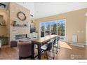 Open-concept living room boasts a stone fireplace, bar-style seating and sliding glass doors to outdoor area at 111 Hunters Cove Rd, Mead, CO 80542