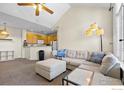Open-concept living space with kitchen view, vaulted ceiling, and plush sectional sofa at 1339 Carlyle Park Cir, Highlands Ranch, CO 80129