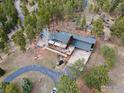 Aerial view showcasing a property with lush green surroundings and a private driveway at 13660 Rampart Dr, Conifer, CO 80433