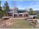 A charming wood-clad house featuring a walkout deck, and a landscaped yard at 13660 Rampart Dr, Conifer, CO 80433