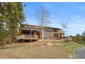 Wood clad home with an expansive deck, perfect for outdoor gatherings at 13660 Rampart Dr, Conifer, CO 80433