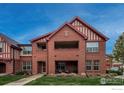 Charming brick building with open-air second floor porch and manicured lawn at 1379 Charles Dr # 4, Longmont, CO 80503
