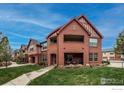 Attractive brick building with open-air second floor porch and lush lawn at 1379 Charles Dr # 4, Longmont, CO 80503