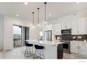 Contemporary kitchen with an island, stainless steel appliances, and access to an outdoor balcony at 1581 Poplar Dr, Erie, CO 80516
