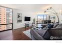 Bright living room with hardwood floors, modern decor, and expansive windows offering city views at 1625 Larimer St # 2601, Denver, CO 80202
