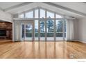 Bright living room featuring hardwood floors, large windows and a stone fireplace at 1629 Timber Ln, Boulder, CO 80304