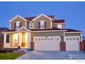Inviting two-story home featuring a three-car garage, covered porch, and charming red shutters at 16341 Clayton St, Thornton, CO 80602