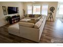 Spacious living room boasts a large sectional sofa, media center, and bright, natural lighting at 16341 Clayton St, Thornton, CO 80602