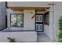 Exterior entry featuring secure front door, stucco, and small patio at 1825 Kendall St # 104, Lakewood, CO 80214
