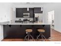 Stylish kitchen featuring dark cabinetry, granite countertops, and bar stool seating at 2001 Lincoln St # 2113, Denver, CO 80202
