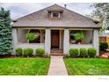 Charming home featuring a well-manicured lawn, mature landscaping, and inviting front porch at 2019 S Grant St, Denver, CO 80210