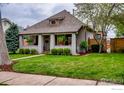 Charming home featuring a well-manicured lawn, mature landscaping, and inviting front porch at 2019 S Grant St, Denver, CO 80210