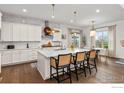Kitchen featuring a large island with seating, stainless appliances, and a view into the adjacent dining area at 2482 Claystone Cir, Erie, CO 80516