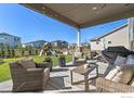 Relaxing covered patio with comfortable seating, perfect for outdoor entertaining and enjoying the backyard at 2482 Claystone Cir, Erie, CO 80516