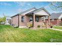 Lovely brick home with a covered front porch, offering a warm and inviting curb appeal at 304 E Nebraska Ave, Berthoud, CO 80513