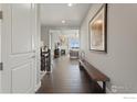 Inviting hallway with hardwood floors leading to an open-concept living space with a fireplace at 3692 Deacon Dr, Mead, CO 80542
