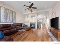 A cozy living room features hardwood floors, a leather couch, fireplace, and a ceiling fan at 3734 Ridgeway St, Boulder, CO 80301