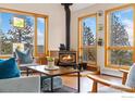 Cozy living room featuring a wood-burning stove, hardwood floors, and abundant natural light at 473 Fred St, Boulder, CO 80302